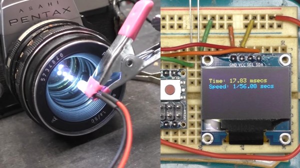 A vintage film camera with a bright light emitting diode shining through it, next to electronic equipment to measure the shutter speed