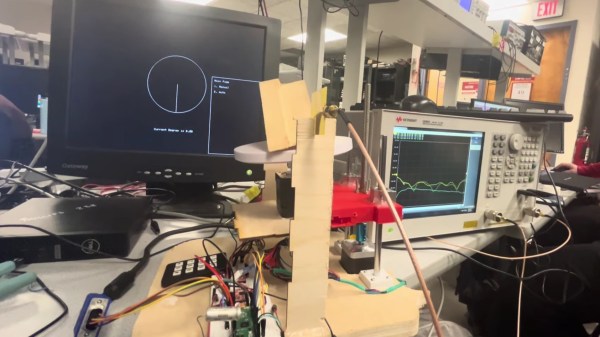 A microwave imaging setup. On the left is a monitor displaying a monochrome GUI. In the center is the RP2040-based positioning and measurement system, and on the right is a vector network analyzer.